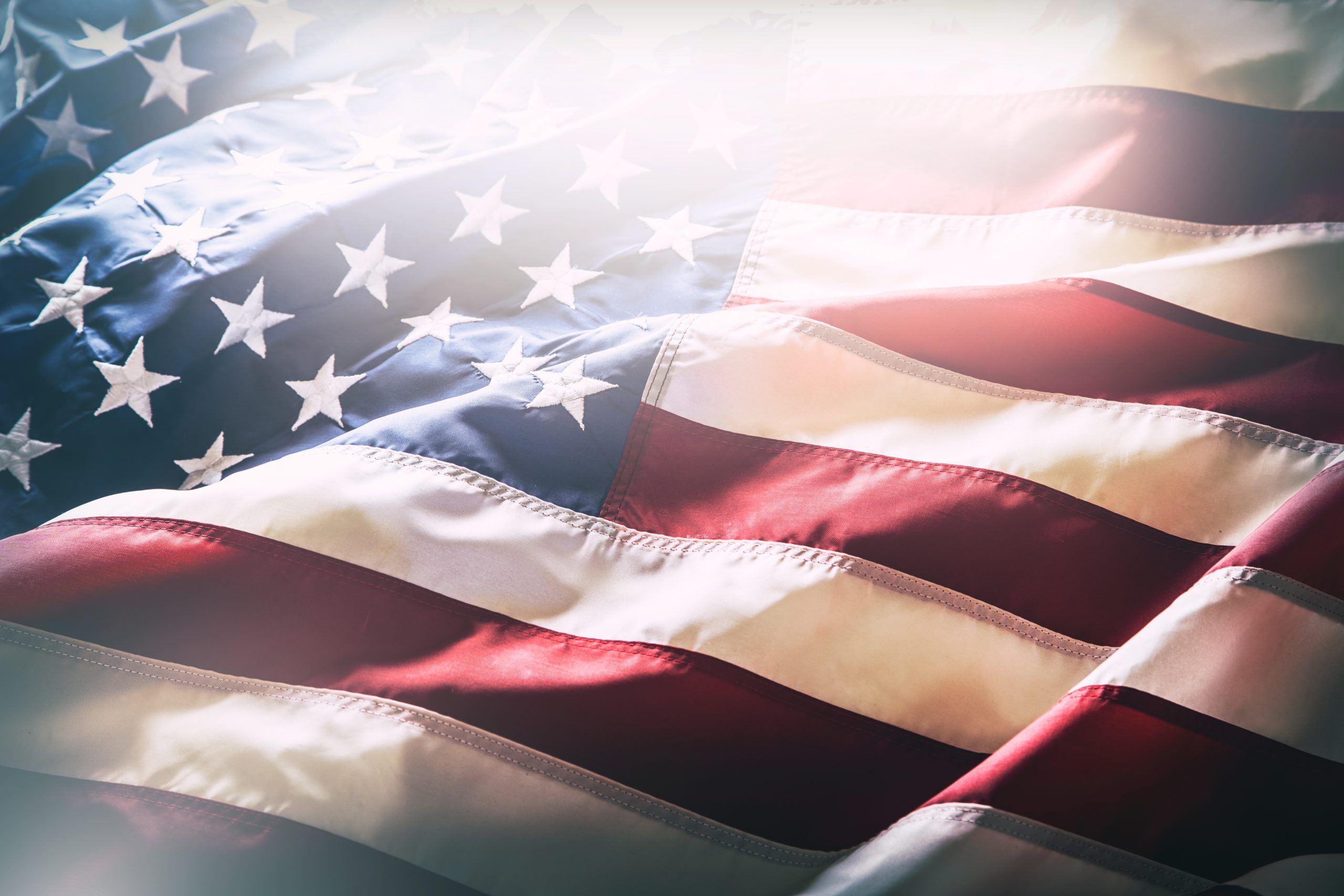 A waving American flag with a feathered white edge border.